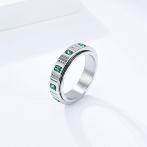 Detail eines silbernen drehbaren Anti-Stress-Rings mit smaragdgrünen Zirkonia-Steinen