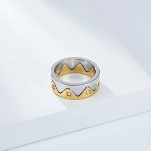 Two-tone silver and gold crown ring with cubic zirconia on a white geometric stand