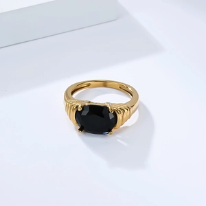 Détail macro d'une bague plaquée or 18 carats avec pierre noire ovale et anneau texturé