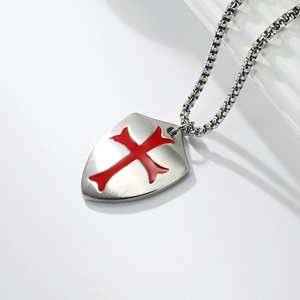 Detail of matte stainless steel shield pendant with a red enamel crusader cross