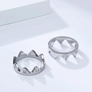 Macro shot of silver crown-shaped mountain rings with polished metal and zircon inlays