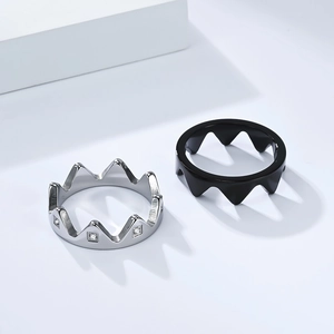 Matching silver crown rings with crystals and black crown band for couples on white podium