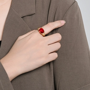 Bague de luxe en titane plaqué or 18 carats avec un grand rubis ovale portée au doigt