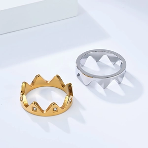Polished gold and silver crown rings with sparkling stones on geometric white blocks
