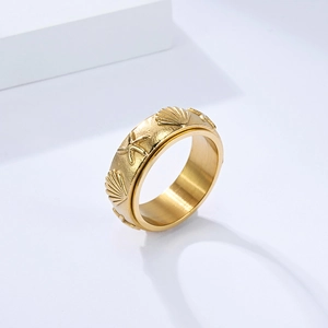 Anillo de acero de titanio dorado con relieve de concha y estrella de mar giratorio