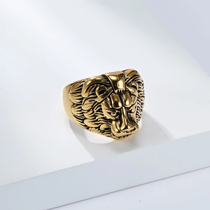 Nahaufnahme eines goldenen Löwenkopf-Rings im Punk-Stil auf weißem Sockel