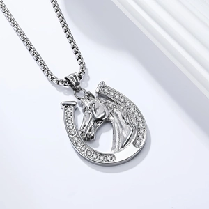 Macro view of silver horseshoe and horse head pendant with sparkling white crystals