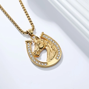 Macro detail of gold horseshoe and horse head pendant with sparkling white cubic zirconia