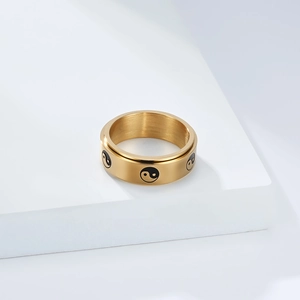 Close-up of golden stainless steel ring featuring engraved Tai Chi Yin Yang symbols