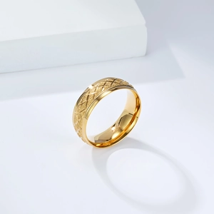 Detail of 18K gold stainless steel ring with diamond cut texture and polished inner band