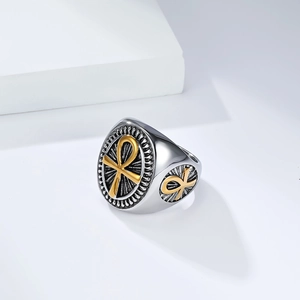 Macro shot of vintage silver signet ring with gold Ankh cross and radial texture