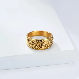 Detailansicht eines Vintage-Gold-Punk-Rings mit geprägten bösen Augen auf weißem Ständer