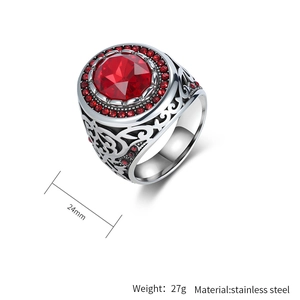 Detail view of vintage stainless steel ring with a large red gem and intricate carvings