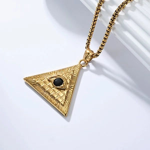 Detailed macro view of gold pyramid pendant with all-seeing eye and black bead