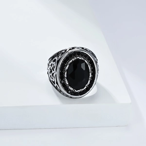 Macro shot of vintage silver steel ring with oval black gemstone and carved details