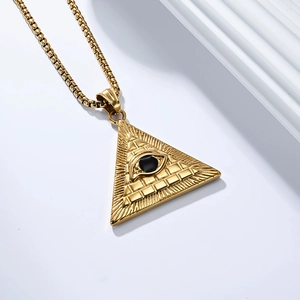 Macro shot of gold Eye of Horus pyramid pendant with sunburst texture and black stone