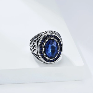 Detail of vintage signet ring with oval blue gemstone and intricate side engravings