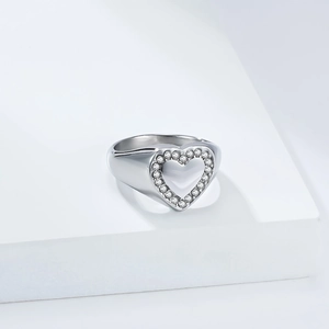 Silver heart signet ring with micro-paved white zircons on a white geometric stand