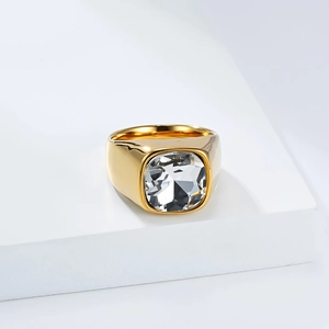 Détail macro d'une bague cocktail dorée avec une grande pierre précieuse carrée taille coussin