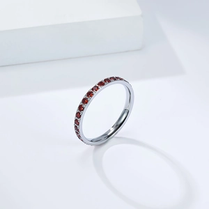 Dettaglio dell'anello in titanio con pavé di pietre rosse e finitura in metallo lucido