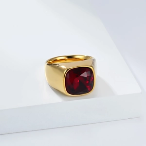 Vue détaillée d'une bague dorée ornée d'une grande pierre rouge de taille carrée