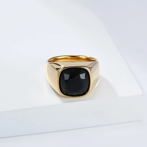 Vue détaillée d'une bague chevalière dorée ornée d'une pierre précieuse noire carrée