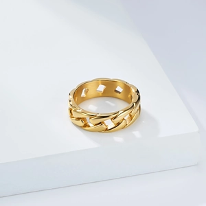 Polished golden stainless steel cuban chain ring for men and women on white pedestal