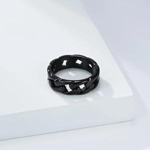 Macro shot of matte black cuban link chain ring on minimalist white platform