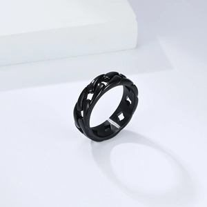 Macro detail of black Cuban link ring featuring textured chain design and polished inner band