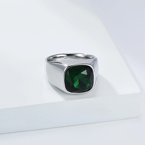Gros plan d'une bague large en argent avec une grande pierre carrée vert émeraude