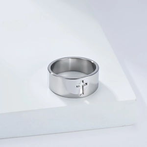 Macro shot of silver titanium steel ring featuring a cutout cross design on a white pedestal