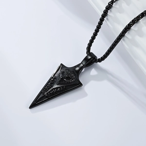 Detailed close-up of a black vintage arrowhead pendant with an eagle relief and rune markings