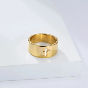 Macro shot of minimalist gold plated stainless steel ring with cutout cross design