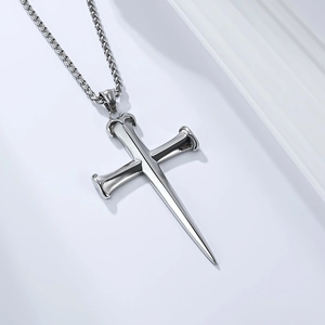 Polished silver punk cross pendant necklace with nail spike detail on woven metal chain