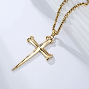 Close-up of golden nail cross pendant with industrial punk aesthetic on heavy chain