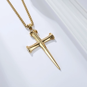 Detail of 18K gold polished nail cross pendant necklace with a classic pearl link chain