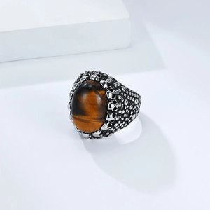 Macro detail of punk skull relief and tiger eye stone inlay on stainless steel ring