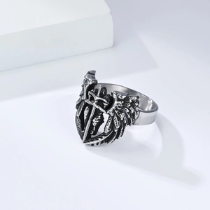 Detail shot of vintage silver ring with relief angel wings and sword in gothic style