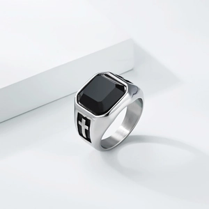 Close-up of men's stainless steel ring with black stone inlay and cross engraving