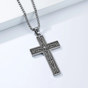 Détail du pendentif croix gothique argentée avec gravure vintage sur chaîne box