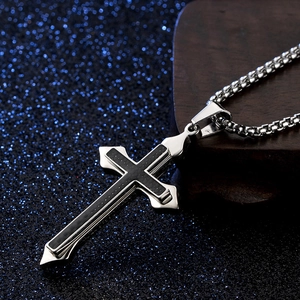 Gros plan du pendentif croix en acier inoxydable avec insert en fibre de carbone noire