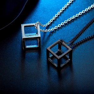 Macro view of hollow cube titanium steel pendants in antique silver and matte black