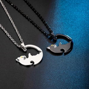 Close-up of titanium steel interlocking cat pendants for couples in black and silver