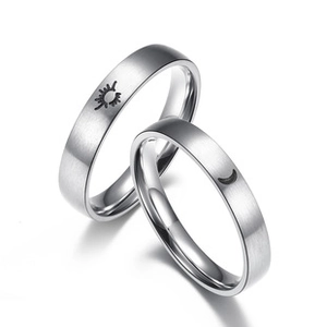 Detail view of silver couple rings with sun and moon engravings and brushed finish