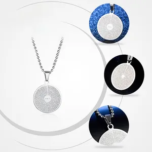 Macro detail of laser engraved scripture on circular stainless steel pendant