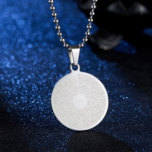 Macro shot of silver stainless steel pendant with laser engraved Shurangama Mantra text