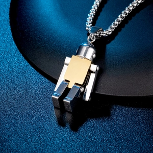 Close-up of titanium steel robot pendant with gold chest plate on a black stand