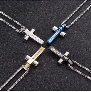 Détail de quatre colliers croix en acier inoxydable en argent, or, bleu et noir avec zircons