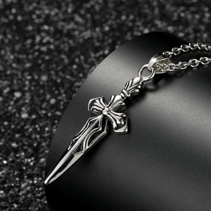 Macro view of vintage silver sword cross pendant with rustic punk metal texture