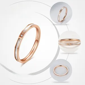 Detailansicht eines Roségoldrings mit weißer Muschel-Einlage und kleinem runden Zirkon